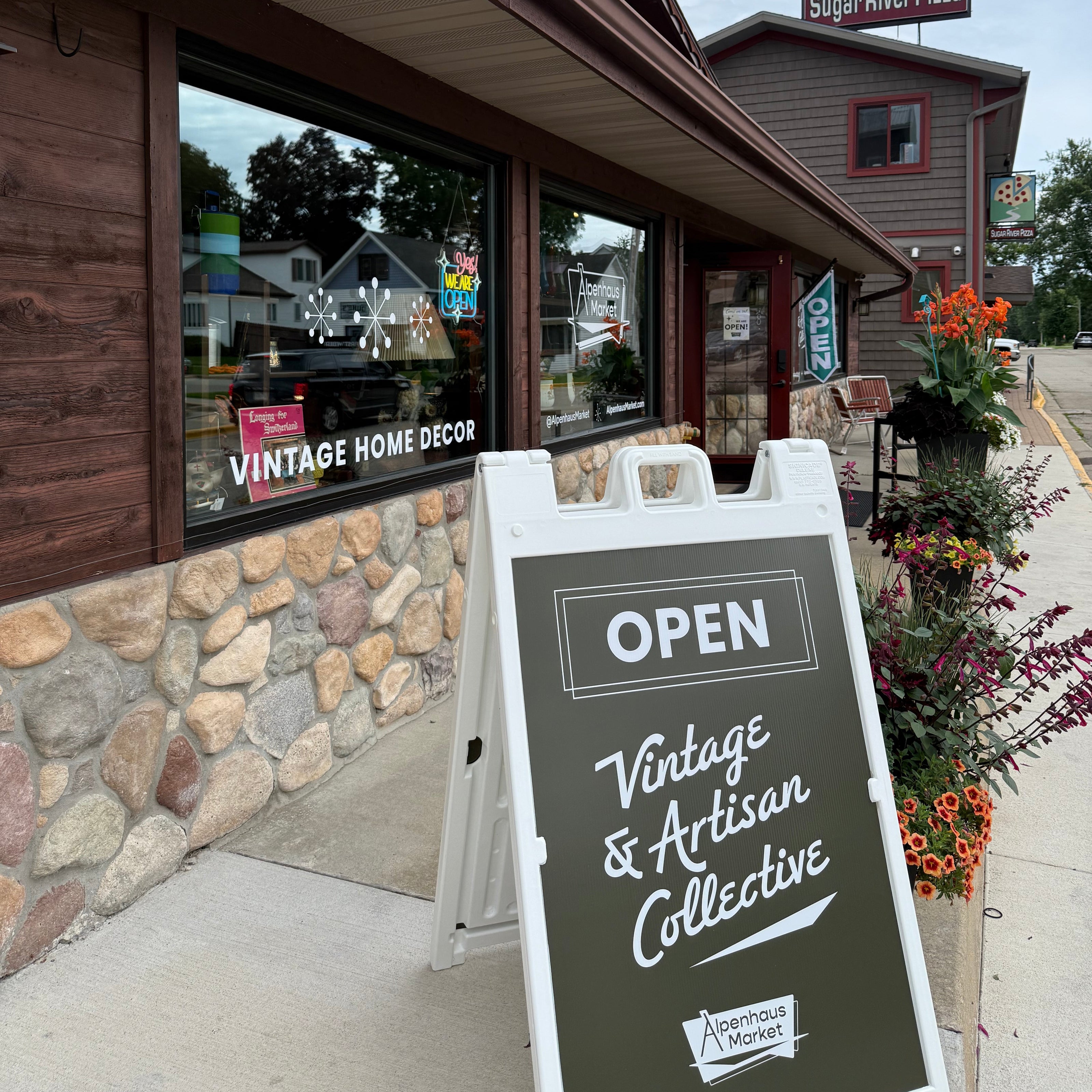 Storefront with a 'Open' sign and 'Vintage & Antique Collective' branding.